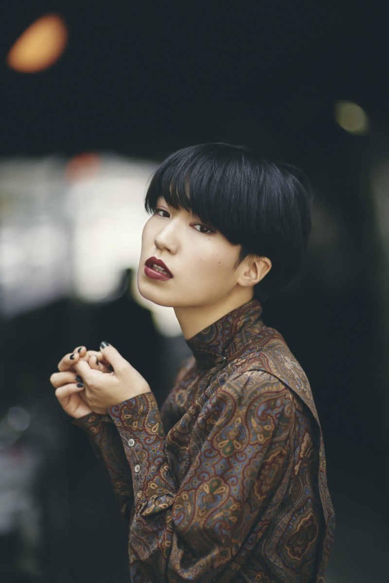 woman wearing brown long-sleeved top standing